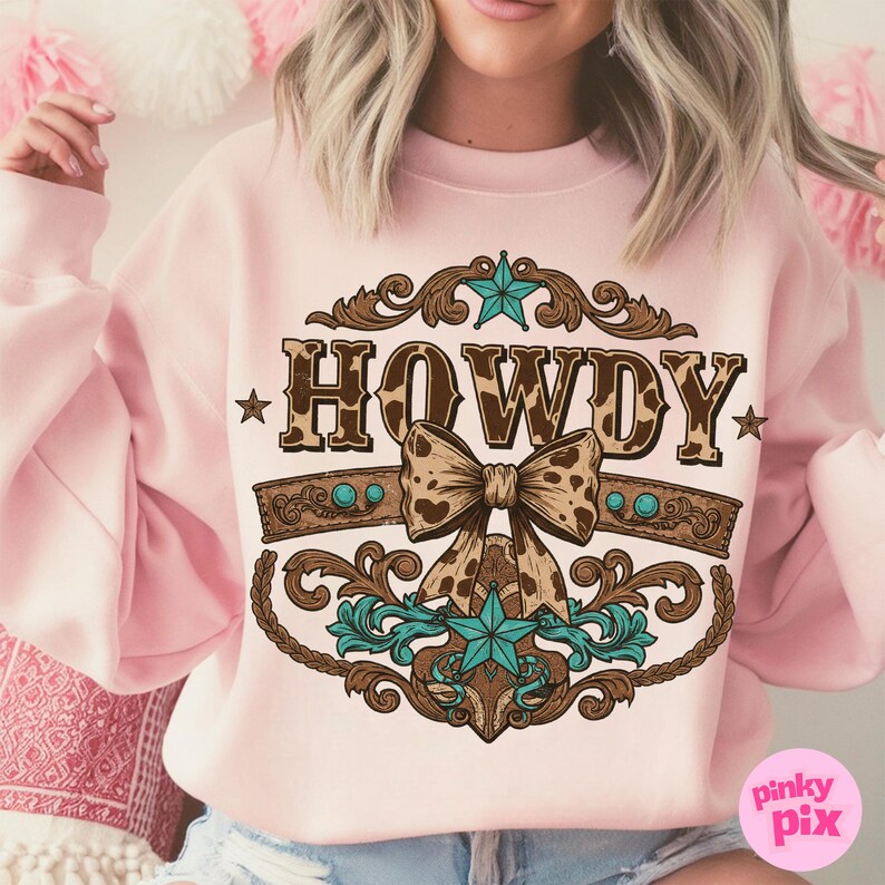 Pu&ograve; includere: Felpa rosa con un designo a stampa leopardo marrone e bianco che dice "Howdy" con un fiocco turchese e marrone e dettagli a stella.