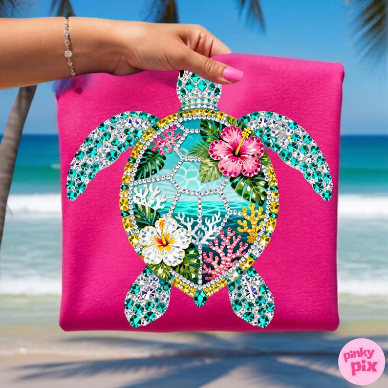 May include: A hot pink tote bag featuring a bejeweled sea turtle design. The turtle has turquoise, gold, and clear crystal accents, with a central ocean scene and hibiscus flowers. The bag is held up against a beach backdrop.