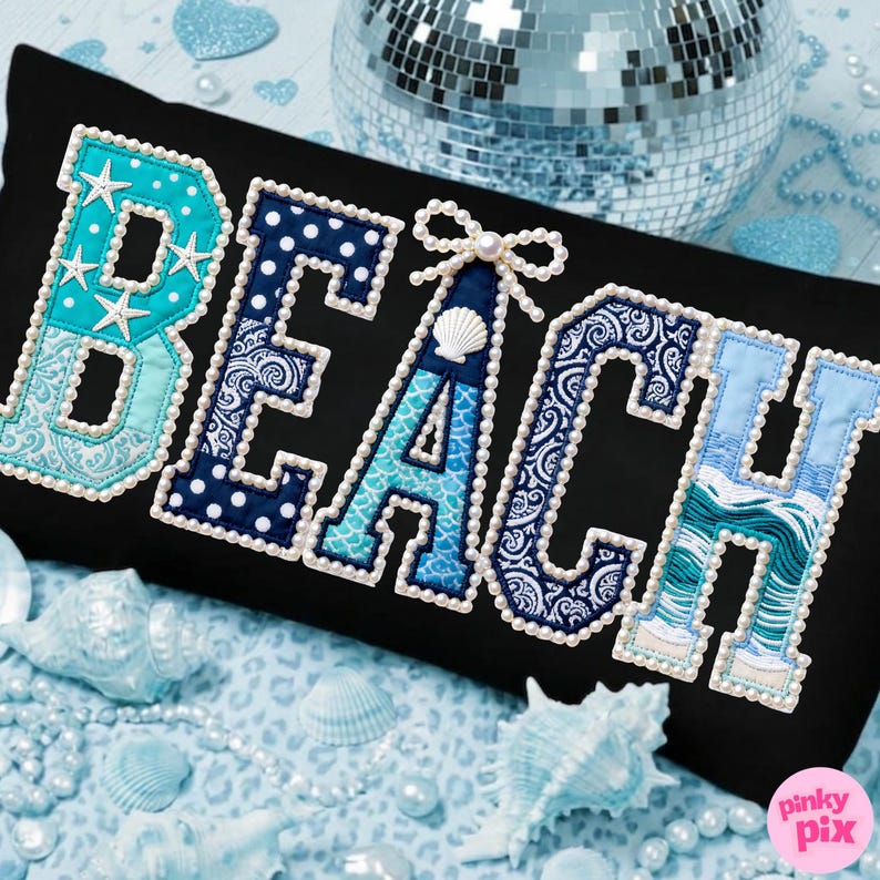 May include: Black rectangular pillow with the word "BEACH" embroidered in various shades of blue and white. The letters are outlined with pearls. The letter "B" has starfish accents, and the letter "A" has a seashell and bow.