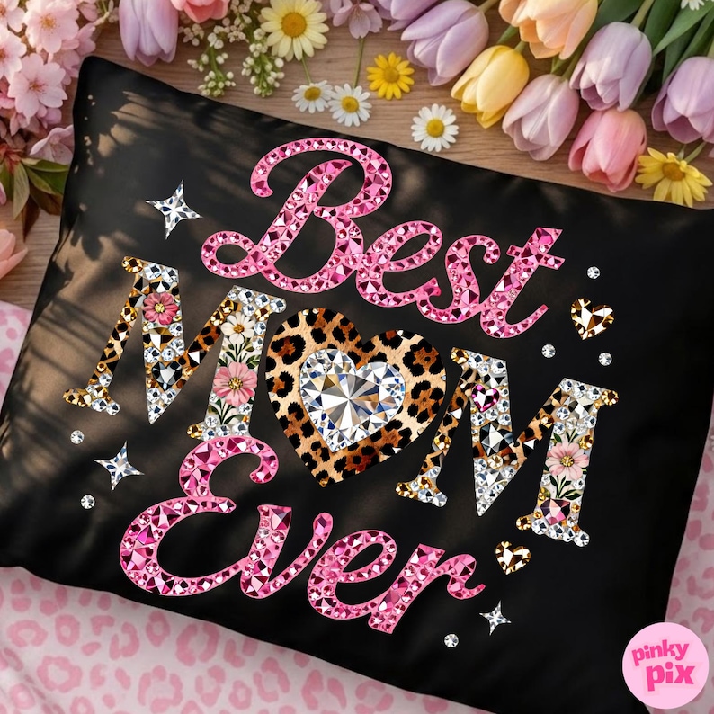 May include: Black pillowcase with the text "Best Mom Ever" in pink rhinestone lettering. The letter "M" is decorated with flowers and the heart is leopard print with a diamond center. Decorative stars and hearts are scattered around the text.