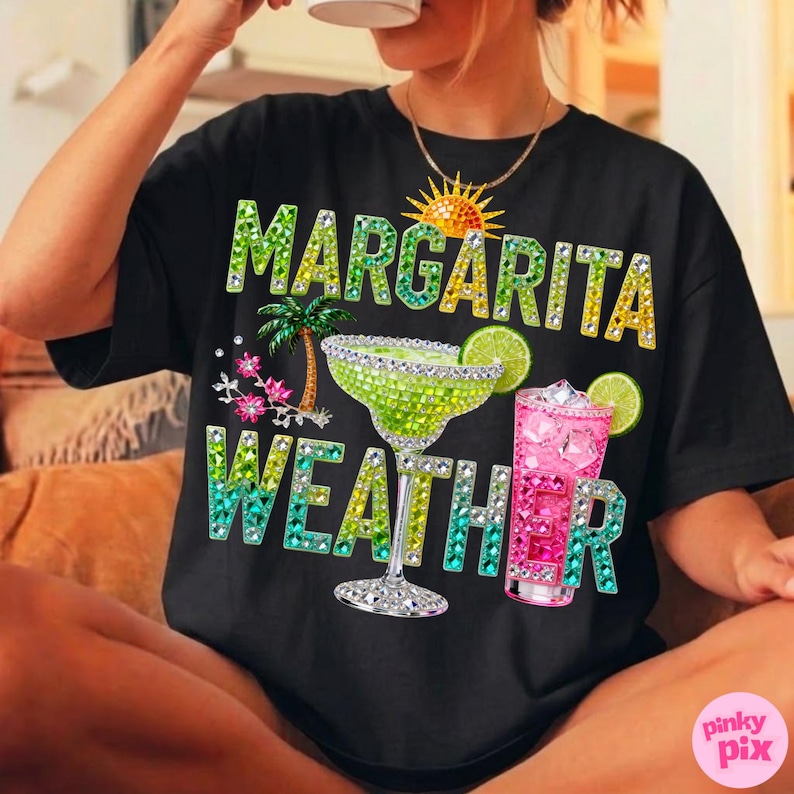 Peut inclure: T-shirt noir avec l'inscription "MARGARITA WEATHER" en lettres orn&eacute;es de bijoux. Le motif comprend une margarita, un cocktail rose, un palmier et un soleil. Un v&ecirc;tement d&eacute;contract&eacute; sur le th&egrave;me de l'&eacute;t&eacute;.