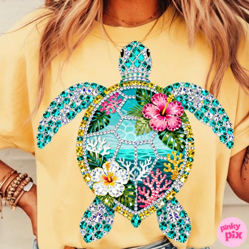 May include: Yellow t-shirt featuring a bejeweled sea turtle design. The turtle has turquoise gem wings and head, with a shell design of tropical flowers, coral, and ocean imagery. The shirt is a solid yellow color.