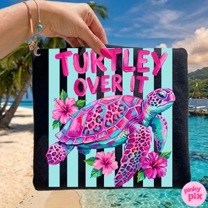 May include: A black tote bag with a colorful design featuring a pink and blue sea turtle, pink hibiscus flowers, and the text "Turtley Over It" in pink. The background has light blue stripes.
