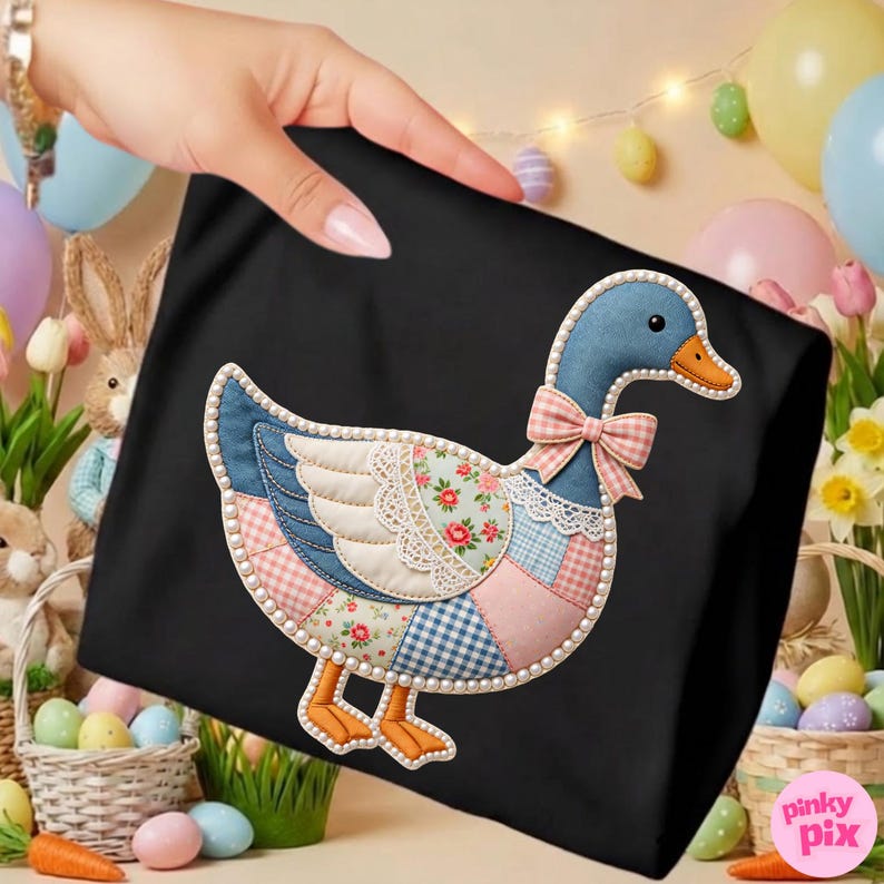 K&ouml;nnte beinhalten: Schwarze Tragetasche mit einem Patchwork-Enten-Design. Die Ente hat einen blauen Kopf, einen orangefarbenen Schnabel und eine rosa Schleife. Der K&ouml;rper ist eine Mischung aus floralen, Vichy- und Spitzenmustern, umrandet mit Perlen. Ostermotiv.