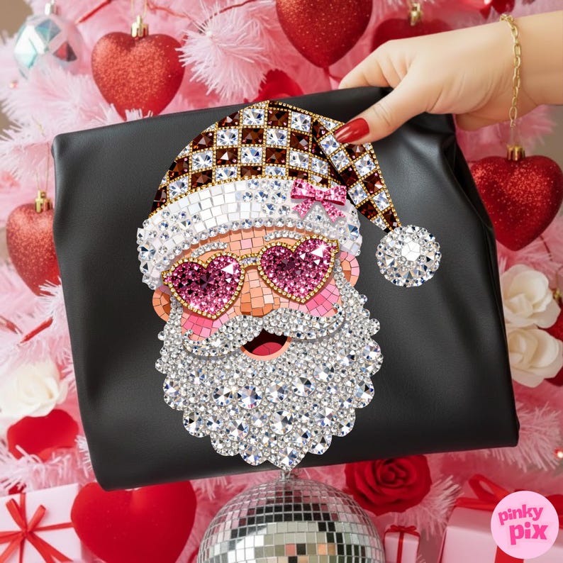 May include: A black pouch featuring a decorative mosaic-style Santa Claus graphic. The Santa design is embellished with sparkling crystals, including pink heart-shaped sunglasses, a checkered hat with a small pink bow, and a white crystal beard.