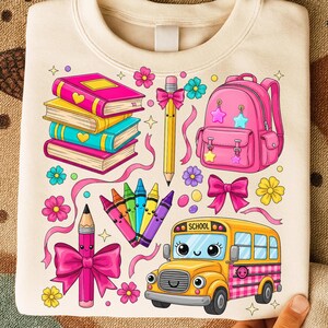 Pu&ograve; includere: Una felpa color crema con una grafica colorata a tema scolastico. Il design include una pila di libri, uno zaino rosa, un autobus scolastico giallo, matite, pastelli e fiori. L'autobus scolastico ha la scritta "SCHOOL".