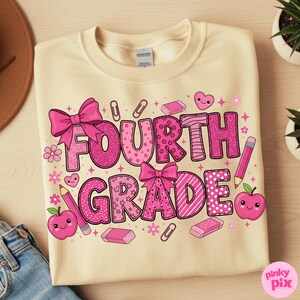 May include: Cream-colored Fourth Grade sweatshirt with a pink graphic. The graphic includes the words "Fourth Grade" in a mix of patterns and fonts, along with bows, pencils, apples, and other school-themed elements.