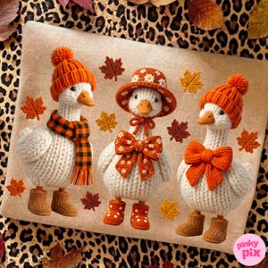 May include: Three white crocheted goose figurines. The left goose wears an orange pom-pom hat, a black and orange plaid scarf, and brown boots. The center goose wears a floral hat and bow with orange boots. The right goose wears an orange hat and bow.