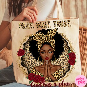 May include: A beige tote bag with a black and gold leopard print design. The bag features a black woman with a leopard print headband, praying with her hands clasped. The text "Pray. Wait. Trust. God has a plan" is printed on the bag.