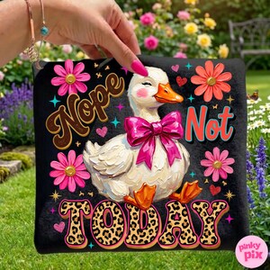 May include: Black decorative pillow featuring a white duck with a pink bow, blush cheeks, and orange beak and feet. The pillow has the words "Nope Not Today" with floral and leopard print accents.