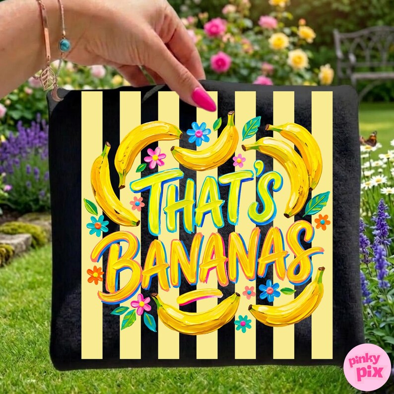 Pu&ograve; includere: Cuscino nero con strisce verticali gialle e nere. Il cuscino presenta un design con banane gialle, fiori blu e rosa e il testo "THAT'S BANANAS" in un carattere colorato.