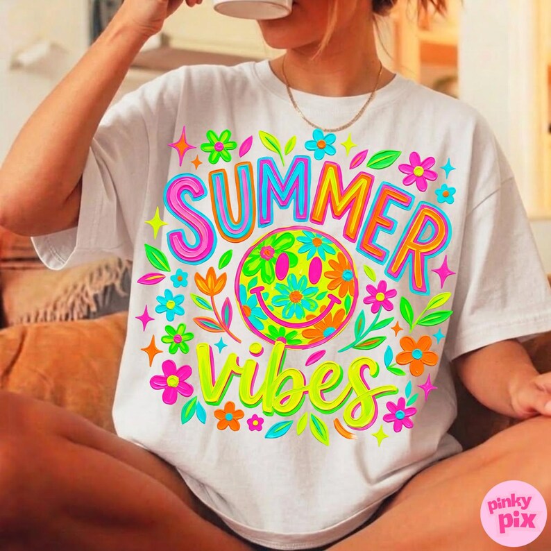 May include: White t-shirt with a colorful "SUMMER VIBES" graphic. The design features a smiley face with flower details, surrounded by flowers and leaves in bright neon colors. The shirt is a casual, relaxed fit.