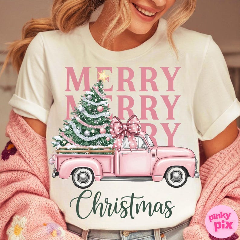 May include: White t-shirt with a pink Christmas design. The design features a pink truck carrying a Christmas tree and a large bow. The words "MERRY MERRY CHRISTMAS" are printed above and below the truck.