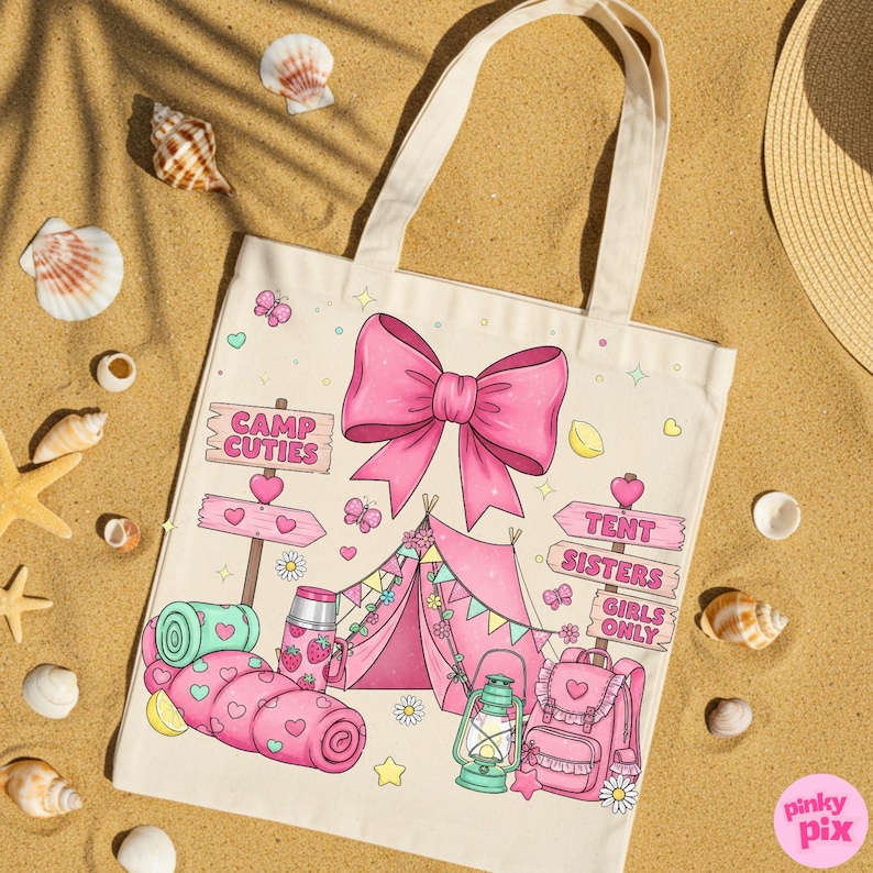 May include: Cream tote bag featuring a pink bow and camping illustrations. The design includes a tent, sleeping bag, backpack, and the text "Camp Cuties" and "Tent Sisters Girls Only". The bag is surrounded by seashells on a sandy surface.