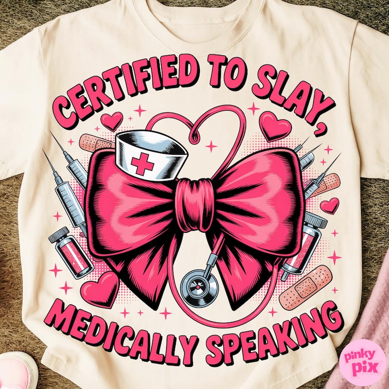 May include: Cream-colored t-shirt with a pink graphic. The graphic features a large pink bow, a nurse's hat, a stethoscope, syringes, bandages, and the text "CERTIFIED TO SLAY, MEDICALLY SPEAKING" in pink.