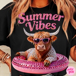 May include: Black t-shirt with a graphic of a Highland cow wearing sunglasses and a bejeweled floatie. The text "Summer Vibes" is above the cow in pink glitter letters. The cow is brown with large horns.