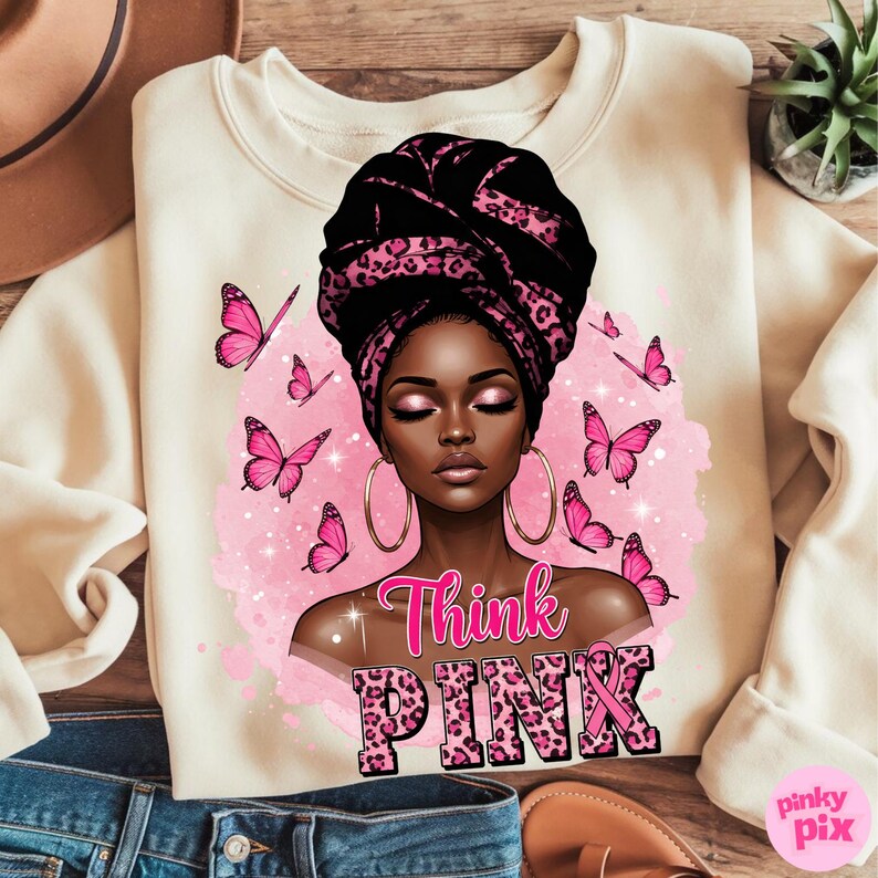 K&ouml;nnte beinhalten: Cremefarbenes Sweatshirt mit einer Grafik einer Frau mit einem schwarz-rosa gemusterten Kopftuch und goldenen Creolen. Rosa Schmetterlinge und die Worte "Think PINK" sind ebenfalls abgebildet. Ein rosa Band ist im Design enthalten.