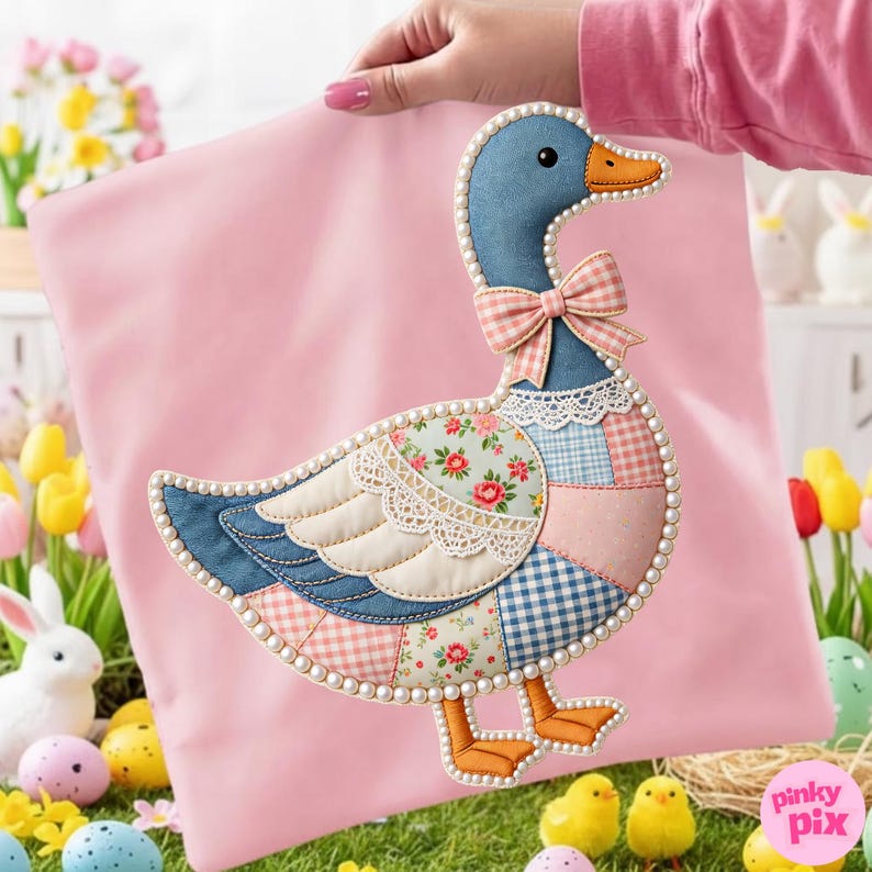 K&ouml;nnte beinhalten: Ein rosa Kissen mit einer dekorativen G&auml;nseapplikation. Die Gans hat einen blauen Kopf und einen Patchwork-K&ouml;rper mit Blumen- und Vichy-Mustern, eine rosa Schleife und eine Perlenborte. Das Bild hat ein Osterthema mit Eiern und K&uuml;ken.