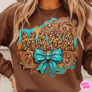 May include: Brown sweatshirt with a decorative design featuring the word "MAMA" in leopard print. The design includes a turquoise bow and ornate, carved details in shades of brown and gold.