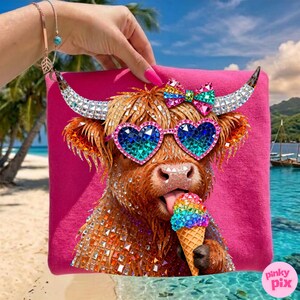 May include: A pink tote bag featuring a rhinestone-studded Highland cow wearing heart-shaped sunglasses and a bow. The cow is holding a rainbow ice cream cone. The background shows a tropical beach scene.