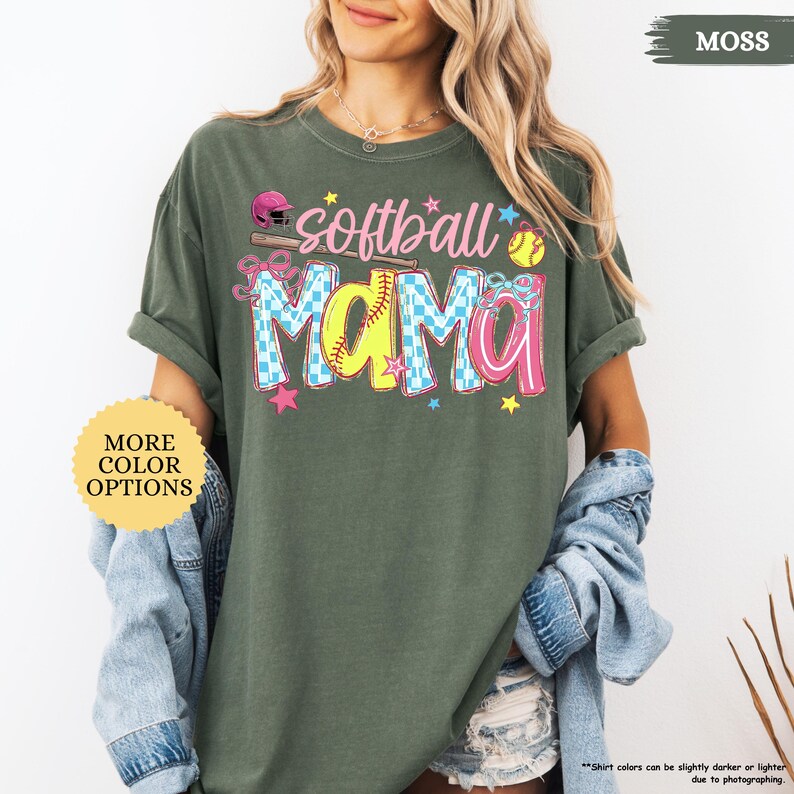 Peut inclure: T-shirt vert mousse avec l'inscription "softball mama" dans un design color&eacute;. Le mot "mama" est en lettres jaunes et &agrave; carreaux bleus. Le t-shirt pr&eacute;sente &eacute;galement une balle de softball, une batte et des &eacute;toiles.