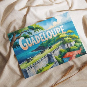 Pode incluir: Ilustração em aquarela de Guadalupe, com a palavra "GUADELOUPE" em letras grandes. A obra retrata uma cena costeira com uma fortaleza, canhões e vegetação exuberante sob um céu azul. A imagem está sobre um tecido neutro.