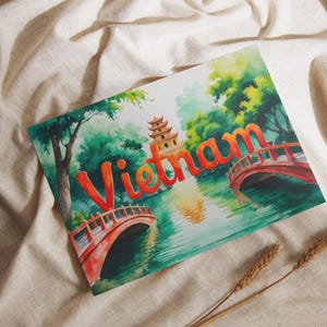 May include: Watercolor print of Vietnam with a pagoda, bridges, and the word "Vietnam" in orange. The artwork features a serene landscape with lush greenery and water reflections.