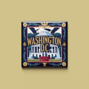 以下が含まれることがあります： ワシントンD.C.の様式化されたイラストが描かれた正方形の装飾タイル。デザインには、ホワイトハウス、2羽のワシ、そして「WASHINGTON D.C.」の文字が金色の文字で、濃い青色の背景に描かれています。