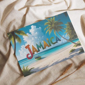 May include: A postcard featuring a tropical beach scene with the word "JAMAICA" in colorful letters. Palm trees frame the turquoise water and white sand beach under a blue sky with fluffy clouds. The postcard rests on a beige fabric.