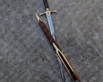 Pode incluir: Uma espada decorativa com uma lâmina prateada e uma empunhadura dourada. A pega é envolta em couro castanho. A espada é exibida com a sua bainha de couro castanho, que tem detalhes dourados.