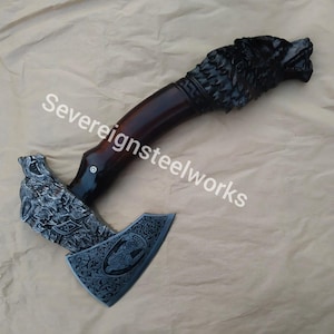May include: A hand-forged axe with a wolf head handle. The axe head is decorated with intricate carvings and the handle is made of dark wood. The axe is a unique and decorative piece.