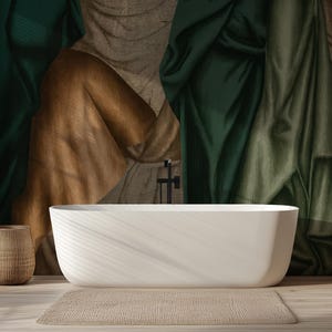 Puede incluir: Un baño moderno con una bañera blanca de forma ovalada, una cesta tejida y una alfombra de color neutro. El telón de fondo presenta telas drapeadas en tonos verdes, marrones y óxido. Una ventana con persianas negras está a la izquierda.