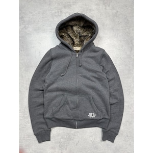 May include: A charcoal gray zip-up hoodie with a faux fur-lined hood. The hoodie features a kangaroo pocket and the letters "HCO" in white on the lower left. The jacket has a drawstring hood and a full-length zipper.