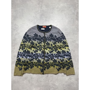 Pode incluir: Cardigã cinza com um padrão floral em preto, amarelo e verde-oliva. O suéter tem decote redondo e fecho de botões. O design floral é repetido na frente e nas mangas.