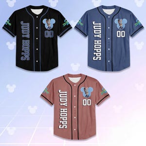 May include: Three baseball jerseys in black, blue, and reddish-brown. Each jersey features the text "JUDY HOPPS" vertically down the left side, a cartoon bunny, and the number "00". The sleeves have a Zootopia logo.