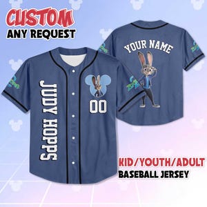 May include: A blue baseball jersey featuring the character Judy Hopps from Zootopia. The jersey has the name "JUDY HOPPS" vertically down the front, the number "00", and the text "YOUR NAME" on the back. The jersey is available in kid, youth, and adult sizes.