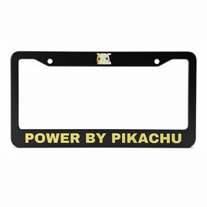 May include: Black license plate frame with the text "POWER BY PIKACHU" in gold lettering. A small Pikachu graphic is centered at the top. The frame has two mounting holes.