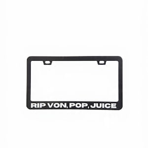 May include: Black license plate frame with the text "RIP VON, POP, JUICE" in white. The frame has a rectangular shape with rounded corners and two mounting holes at the top.