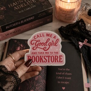 May include: A die-cut sticker with a light pink background and dark pink text that reads, "CALL ME A Good girl AND TAKE ME TO THE BOOKSTORE." The sticker features a scalloped edge design and small star accents, presented in a clear, readable font style.