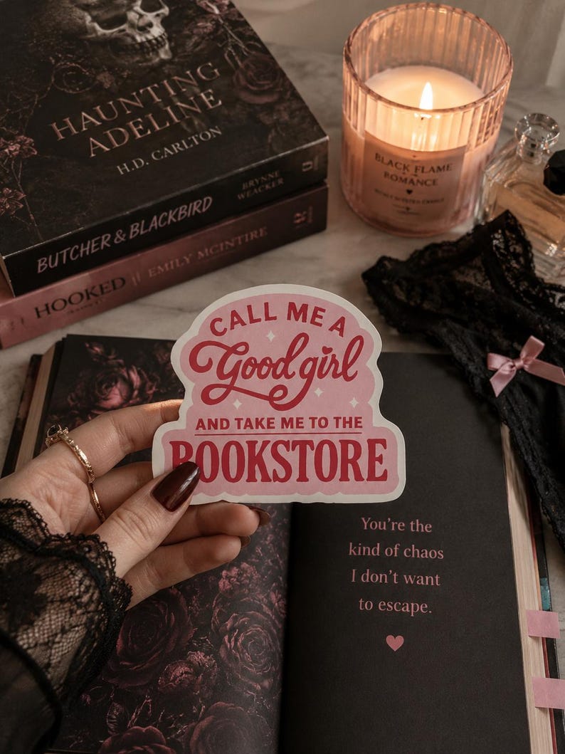 May include: A die-cut sticker with a light pink background and dark pink text that reads, "CALL ME A Good girl AND TAKE ME TO THE BOOKSTORE." The sticker features a scalloped edge design and small star accents, presented in a clear, readable font style.