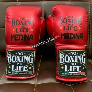 May include: A pair of red boxing gloves with black lettering that reads "No Boxing No Life Medina" and "No Boxing No Life The Championship Line".