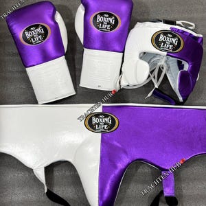 May include: A set of purple and white boxing equipment, including gloves, a head guard, and a groin protector. The equipment features the text "No Boxing No Life" in a white circle with a black outline.