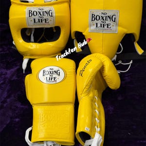 May include: Yellow boxing headgear and gloves with white laces. The headgear has a padded face mask and the gloves have a velcro closure. Both items have the text "NO BOXING NO LIFE" printed on them.