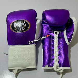 May include: A pair of purple boxing gloves with white laces and a white cuff. The gloves have the text "No Boxing No Life" in gold lettering on the front.