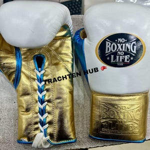 May include: Pair of boxing gloves with white, gold, and blue accents. The gloves feature the text "NO BOXING NO LIFE" and a lace-up design. The gloves are made of leather.