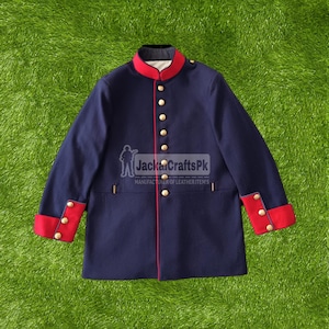 Puede incluir: Chaqueta azul marino de estilo militar con ribetes rojos y botones dorados. La chaqueta presenta un cuello alto, puños rojos con botones dorados y un ribete rojo en la parte delantera. El logotipo "JackaCraftsPk" es visible.