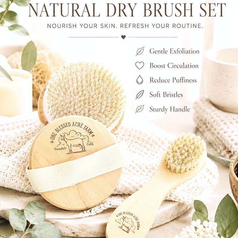 May include: A natural dry brush set featuring a round wooden brush with a canvas strap and a smaller handled brush. Both brushes have light-colored bristles and are branded with the text One Blessed Acre Farm, Ferndale, Calif.
