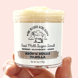 May include: A white jar of brown sugar vanilla goat milk sugar scrub with a black and white label that reads "One Blessed Acre Farm Ferndale Calif. Goat Milk Sugar Scrub Refresh Rejuvenate Renew Brown Sugar Vanilla Net Wt. 6oz (170g)"