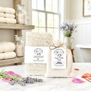 May include: A beige sisal soap pouch and a small fabric bag containing a goat milk soap bar. The pouch label reads One Blessed Acre Farm Sisal Soap Pouch. The bag label reads One Blessed Acre Farm Goat Milk Soap Fresh Lavender Net Wt 113g.