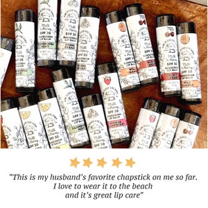 May include: A collection of 15 different flavored lip balms with SPF 30 sunscreen. The lip balms are in black tubes with white labels and feature a variety of flavors, including Farmhouse Mint, Fresh Cream, Wild Orange, Black Cherry, Summer Strawberry, and more.